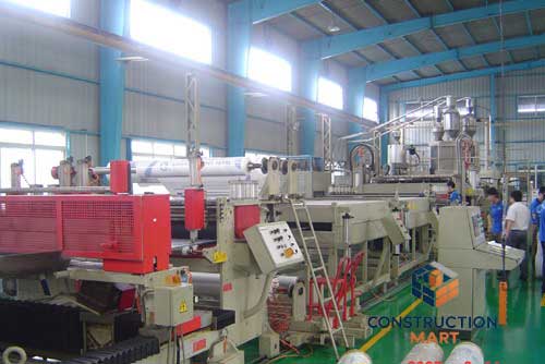 Constructionmart’s polycarbonate hollow sheet production line imported from OMIPA Italy, with staff standing beside the advanced extrusion equipment