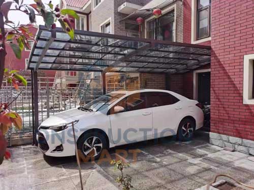 Polycarbonate carport installed under a residential building providing covered parking for one vehicle
