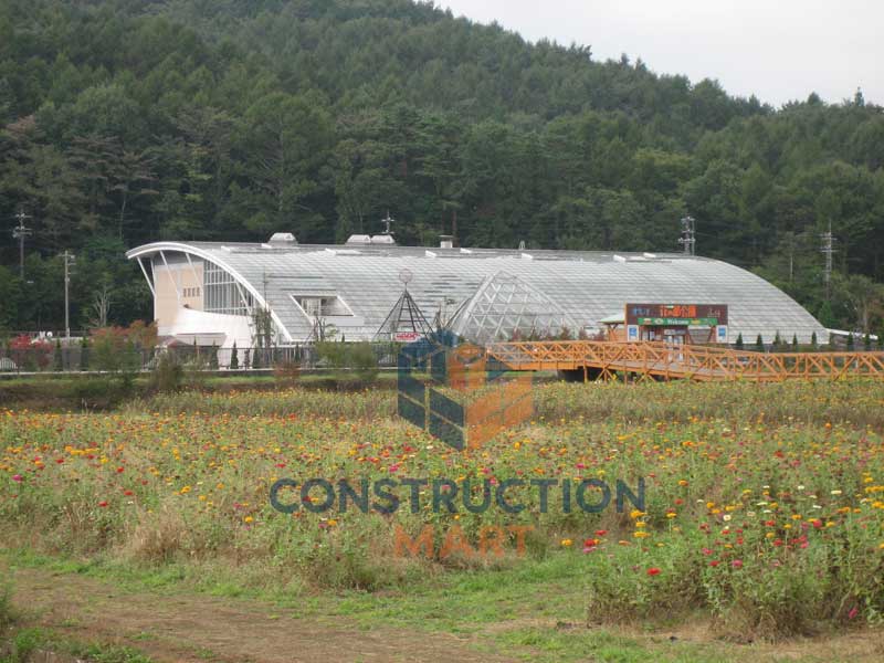 Botanical garden conservatory with tropical plants and curved polycarbonate roof structure